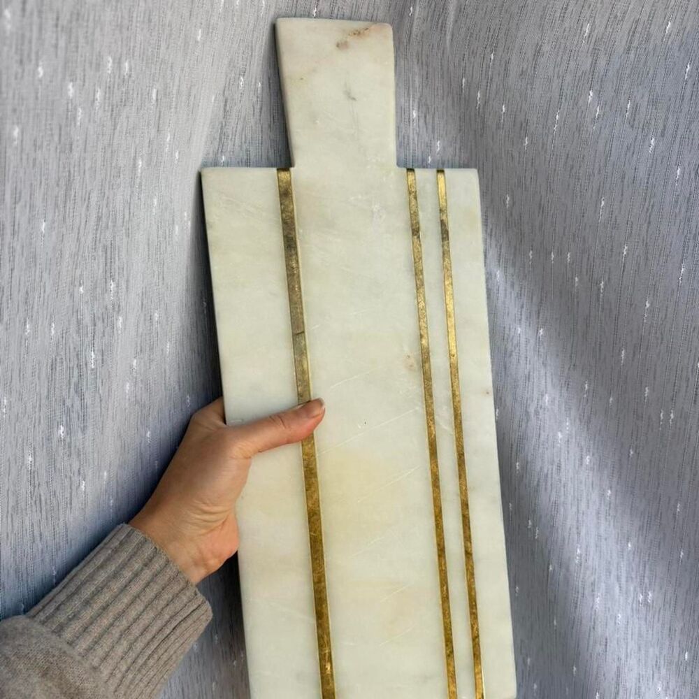 White marble cutting board with gold brass accents